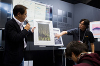 ビデオジェット・エックスライト社の冨川丈司さん（右）は4日間通して、私たちの話をうまく引き出してくださいました。会長の蓮見さん（左）が見せているのはフレスコ壁画にブリントした松木さんの作品。